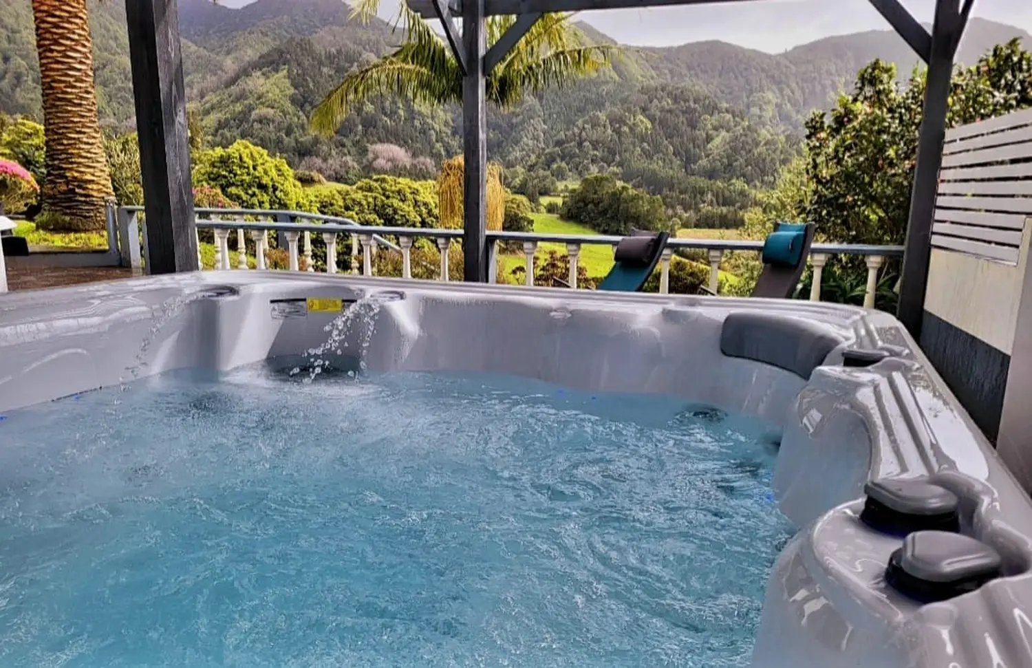 Villa Magia Verde – ein Whirlpool auf dem Balkon oder der Terrasse mit malerischem Blick auf üppig grüne Hügel und Berge.
